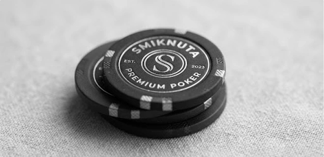 Een stapel zwarte "Smiknuta Premium Poker" fiches op een lichte stoffen achtergrond.